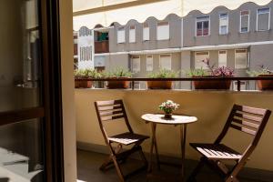 2 stoelen en een tafel op een balkon met bloemen bij Oxilia Flat - Loreto District in Milaan