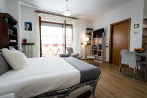 een slaapkamer met een groot bed en een eetkamer bij Oxilia Flat - Loreto District in Milaan