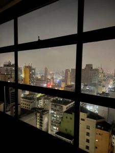 a view of a city skyline from a window at Loft Mirante 3224 in Sao Paulo