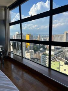 a view of a city from a large window at Loft Mirante 3224 in Sao Paulo