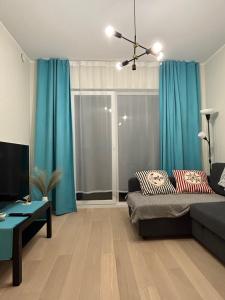 a living room with blue curtains and a couch at Haki Apartment in Tartu