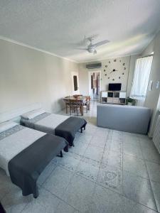 ein Schlafzimmer mit 2 Betten und ein Esszimmer mit einem Tisch in der Unterkunft Casa vacanze il fiore di loto in Zibido San Giacomo