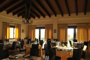 a dining room with tables and chairs and windows at Apartamento Abuela Benita in Cebreros