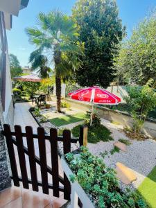 einen Garten mit einem Zaun und einer Palme in der Unterkunft Casa vacanze il fiore di loto in Zibido San Giacomo