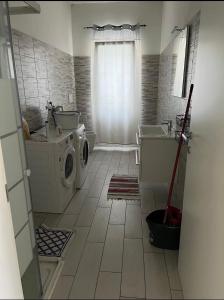 uma casa de banho com uma máquina de lavar roupa e um lavatório em B&B Treviso em Treviso