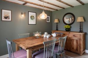 een eetkamer met een houten tafel en stoelen bij Beinn Cottage - Seasgair Lodges in Kincraig