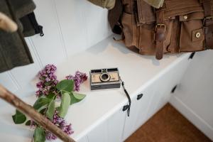 een camera op een tafel naast een tas en bloemen bij Beinn Cottage - Seasgair Lodges in Kincraig
