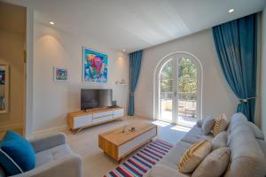 ein Wohnzimmer mit einem Sofa und einem TV in der Unterkunft 1 Bedroom Apartment In Centrale By 2bhome in Tivat