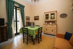 a dining room with a green table and chairs at Il Gelsomino in Palermo +12 photos