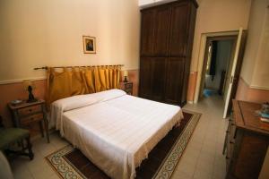 Schlafzimmer mit einem Bett und einem Holzschrank in der Unterkunft Il Gelsomino in Palermo