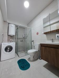a bathroom with a shower toilet and a washing machine at The Romantic Place in Skopje