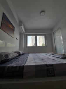 a large bed in a room with two windows at The Romantic Place in Skopje