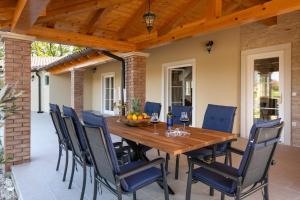 an outdoor dining room with a wooden table and chairs at Villa Clara in Kavran