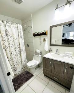 y baño con aseo, lavabo y ducha. en Awesome Apartment near the Beach en Naples