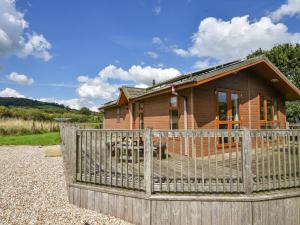 a wooden house with a fence in front of it at The Hideaway in Bridport