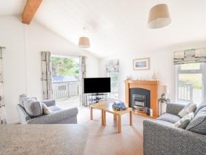 a living room with a fireplace and a tv at The Hideaway in Bridport