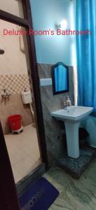 een badkamer met een wastafel en een spiegel bij Hotel Nirmala Inn in Jamūi