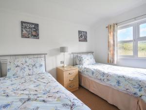a bedroom with two beds and a window at The Hideaway in Bridport