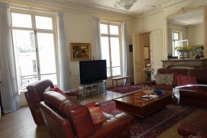 a living room with a couch and a tv at Monceau/Villiers : Magnifique appartement 6P in Paris