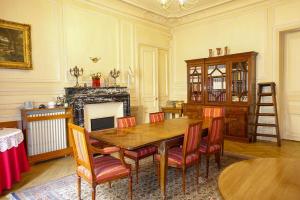 a dining room with a table and chairs and a fireplace at Monceau/Villiers : Magnifique appartement 6P in Paris