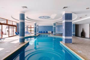 uma piscina com paredes de azulejos azuis e um tecto em Alua Helios Bay - All Inclusive em Obzor