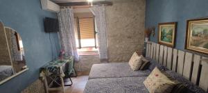 een slaapkamer met blauwe muren en een bed en een raam bij Habitación en Ocaña in Ocaña