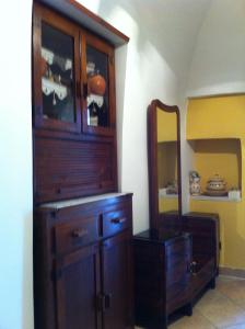 a large wooden cabinet in a room with a mirror at villa ottocento in Ostuni