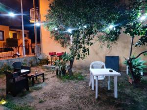 a white table and chairs under a tree at night at La manSarda in Tortolì