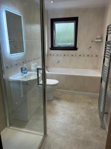 a bathroom with a tub and a toilet and a sink at Inveroran in Campbeltown