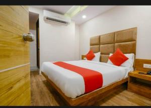 1 dormitorio con 1 cama grande con almohadas rojas en HOTEL SAFARI INN en Ahmedabad