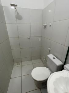 a white bathroom with a toilet and a sink at Suíte central Pousada in Jijoca de Jericoacoara +34 photos