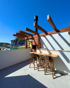 two tables and chairs on the roof of a building at Casa Rio - 04 Quartos de Frente para o Mar in Guarda do Embaú