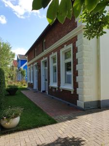 a brick house with white windows and a courtyard at Gartenblick in Oldenburg