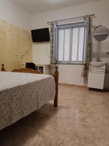 a bedroom with a bed and a sink and a window at Hostal Bélgica in Palmanova