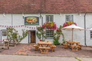 eine Gruppe von Picknicktischen außerhalb eines Gebäudes in der Unterkunft Tiger Inn _ Minnie in Eastbourne