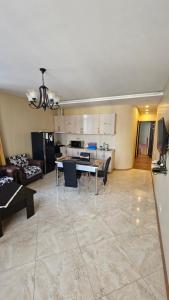 a living room and kitchen with a table and chairs at Apartament in Batumi