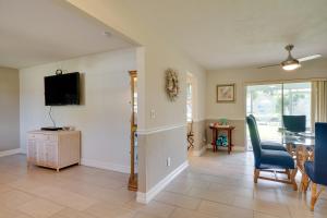 a living room with a table and chairs and a television at Waterfront Cape Coral Home Dock and Screened Porch in Cape Coral