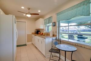 cocina con nevera, mesa y ventana en Waterfront Cape Coral Home Dock and Screened Porch, en Cabo Coral