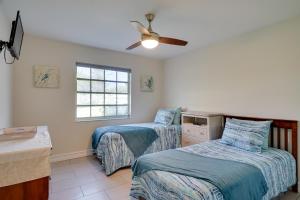 1 dormitorio con 2 camas y ventilador de techo en Waterfront Cape Coral Home Dock and Screened Porch, en Cabo Coral