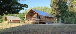 a house with a metal roof in a field at Glamping Podere Poggiagrilli in San Gervasio