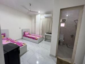 a white room with two beds and a bathroom at Moon light Hotel in Kafr Mas‘ūd