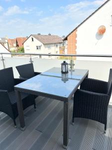 a glass table on a balcony with chairs at Ferienwohnung mit Balkon in Calden in Calden