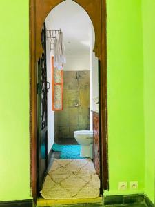 a bathroom with a toilet and a green wall at RIAD GALIYA in Marrakesh