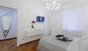a white bedroom with a bed and a mirror at La Roma di Cecilia in Rome