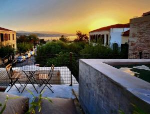 a patio with a table and chairs and a sunset at Amalen Suites Adults Only in Rethymno