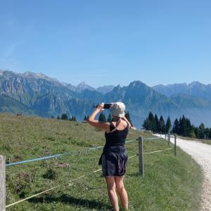 uma pessoa tirando uma foto das montanhas em La Casa di Anna nel Parco delle Dolomiti Croce D'Aune em Pedavena