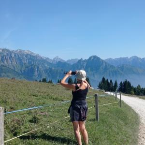a person taking a picture of the mountains at La Casa di Anna nel Parco delle Dolomiti Croce d' Aune 1000 ml slm in Pedavena