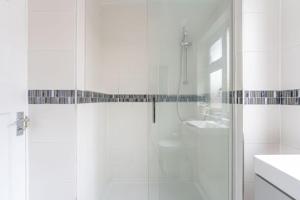 a white bathroom with a shower and a sink at Cosy 3 Bedroom Apartment- 6 Guests with Free Parking in Wyken