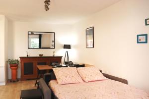 a bedroom with a bed and a desk and a mirror at Le Chapitre Spacieux - parking en résidence fermée in Toulouse