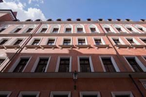 un edificio alto de ladrillo con ventanas y luz de la calle en Palazzo Rosso Old Town, en Poznan